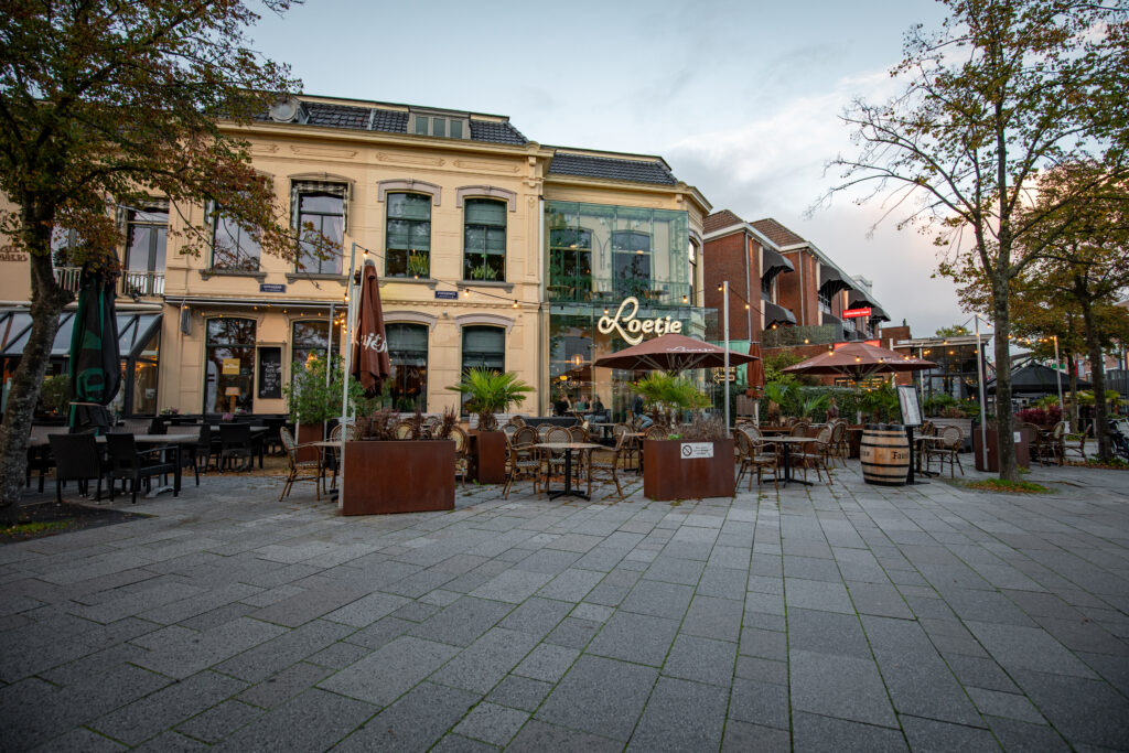 Buitenkant van Loetje Leeuwarden met een ruim terras, parasols en het herkenbare Loetje-logo op de gevel.