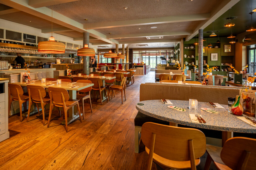 Ruim en sfeervol interieur van Loetje Vught met gedekte tafels en de bar aan de zijkant.