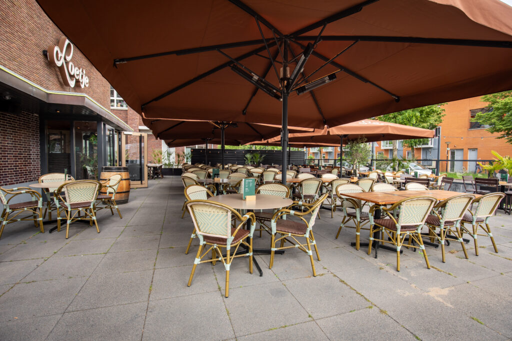 Ruim terras van Loetje Zeist met grote parasols en zitplaatsen voor groepen.